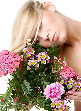 Lovely blond and tall beauty playing with flowers